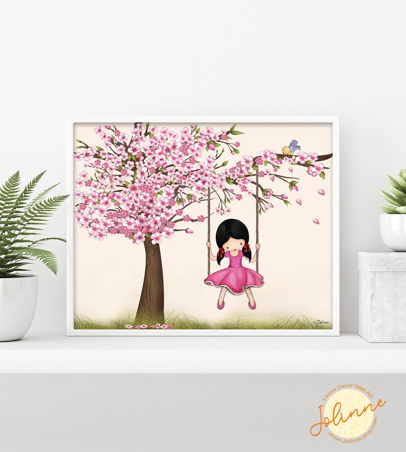 Puede incluir: Una ilustraci&oacute;n digital de una ni&ntilde;a con cabello negro y un vestido rosa balance&aacute;ndose en un columpio de cuerda de un &aacute;rbol de cerezo en flor rosa. El fondo es de color melocot&oacute;n claro.