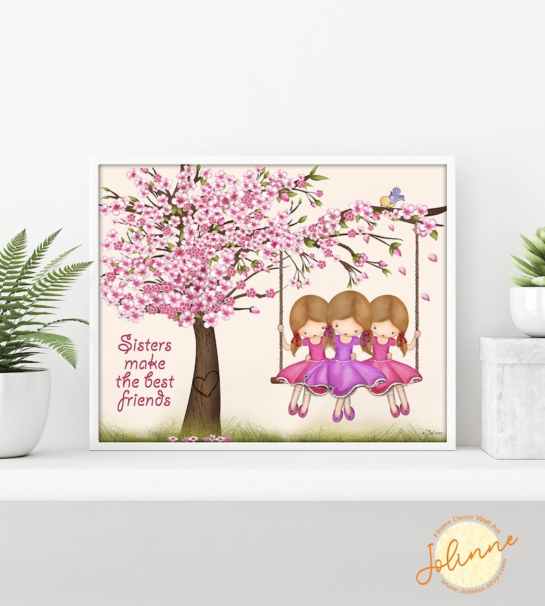 Puede incluir: Tres chicas con vestidos rosas y cabello rubio est&aacute;n sentadas en un columpio debajo de un cerezo en flor rosa. El texto "Sisters make the best friends" est&aacute; escrito en rosa en el lado izquierdo de la imagen.