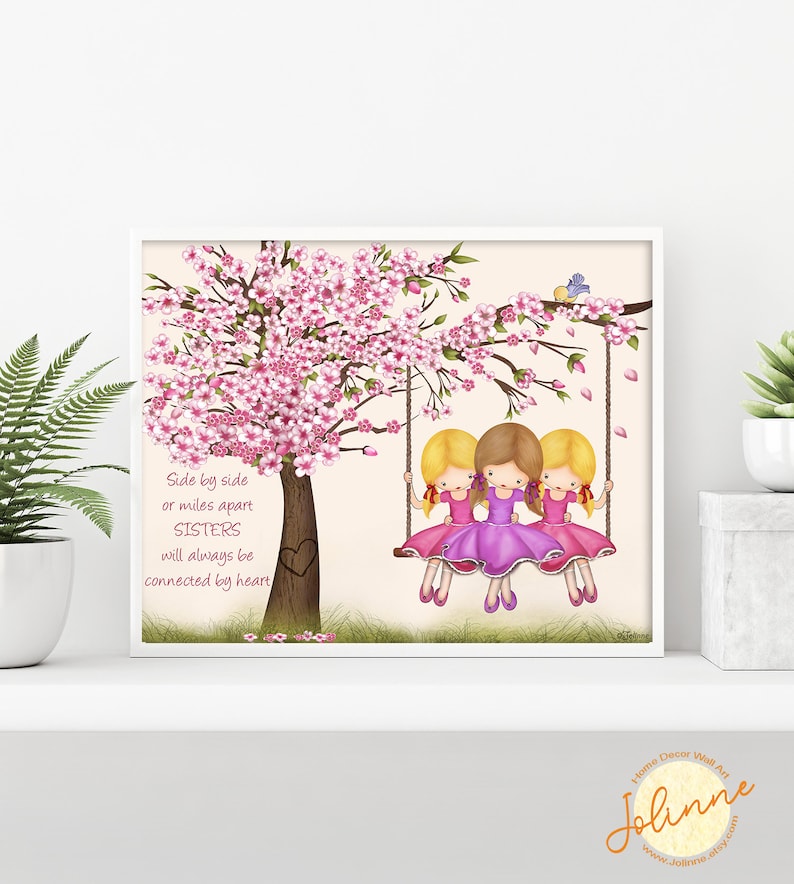 Puede incluir: Tres hermanas en un columpio bajo un cerezo en flor rosa. El texto dice: "Lado a lado o a kil&oacute;metros de distancia, las HERMANAS siempre estar&aacute;n conectadas por el coraz&oacute;n."