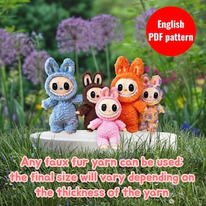 May include: Five crocheted plush toys with large eyes and hoods, featuring blue, brown, pink, orange, and multicolored patterns. A red circle contains the text English PDF pattern, and text below states any faux fur yarn can be used.