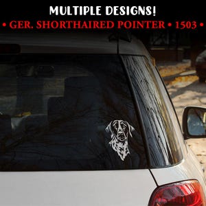 Puede incluir: Una calcomanía de vinilo blanco de un perro Braco Alemán en la ventana de un coche. La calcomanía es un dibujo lineal detallado de la cabeza y los hombros del perro. El texto "MULTIPLE DESIGNS! GER. SHORTHAIRED POINTER • 1503" está en la parte superior.