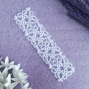 My 'Janessa' Version 3 bookmark in white cotton thread on a mid purple shimmery background.