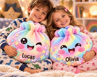 May include: Two round, rainbow-colored plush pillows with smiling faces, star accents, and pink cheeks. One pillow features the name Lucas in black text, and the other features the name Olivia in black text. Both pillows have a gathered top design.