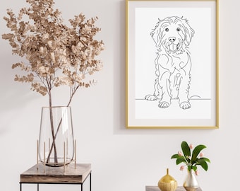 May include: A black and white line drawing of a dog sitting with its tongue out. The drawing is framed in a gold frame and hanging on a white wall.