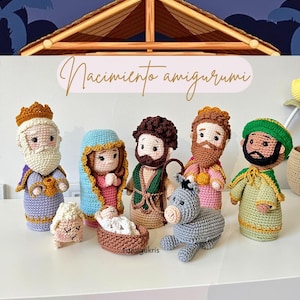 May include: A collection of handmade amigurumi figures depicting a nativity scene. The set includes figures of the three wise men, Mary, Joseph, baby Jesus, a lamb, and a donkey. The figures are crocheted in various colors and are displayed on a white surface.