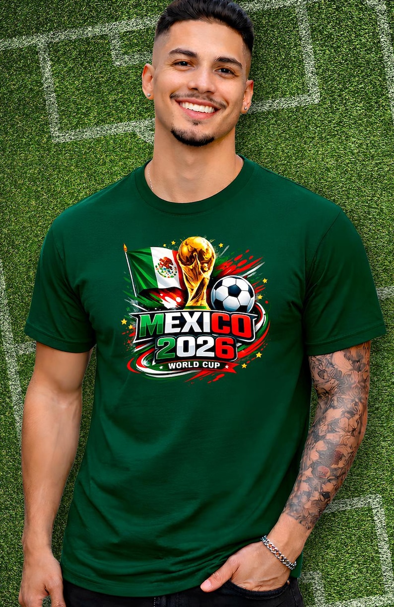 Puede incluir: Camiseta verde con un dise&ntilde;o gr&aacute;fico para la Copa Mundial de 2026 en M&eacute;xico. El dise&ntilde;o incluye la bandera mexicana, un bal&oacute;n de f&uacute;tbol y el trofeo de la Copa del Mundo. El texto "MEXICO 2026 WORLD CUP" est&aacute; presente.