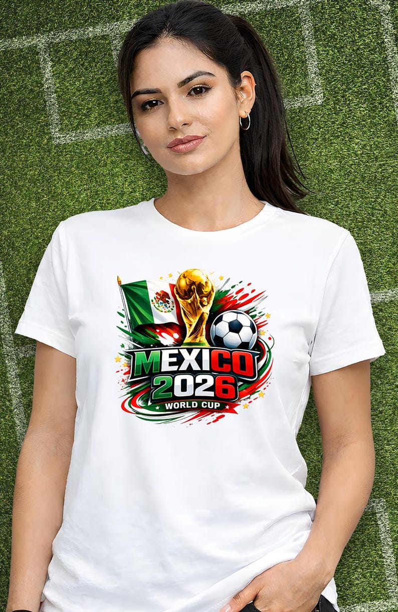 Puede incluir: Camiseta blanca con un dise&ntilde;o gr&aacute;fico colorido para la Copa del Mundo de 2026 en M&eacute;xico. El dise&ntilde;o incluye la bandera mexicana, un bal&oacute;n de f&uacute;tbol y el trofeo de la Copa del Mundo. El texto "MEXICO 2026 WORLD CUP" es visible.