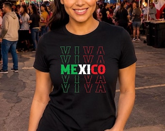 May include: A black short-sleeved t-shirt featuring the text VIVA repeated four times with the word MEXICO centered in the middle. The word MEXICO is printed in the colors of the Mexican flag, green, white, and red, while the word VIVA is outlined.