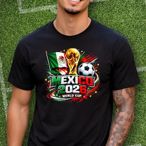 Puede incluir: Camiseta negra con un dise&ntilde;o gr&aacute;fico colorido que anuncia la Copa del Mundo de 2026 en M&eacute;xico. El dise&ntilde;o incluye la bandera mexicana, un bal&oacute;n de f&uacute;tbol y el trofeo de la Copa del Mundo. El texto "MEXICO 2026 WORLD CUP" es visible.