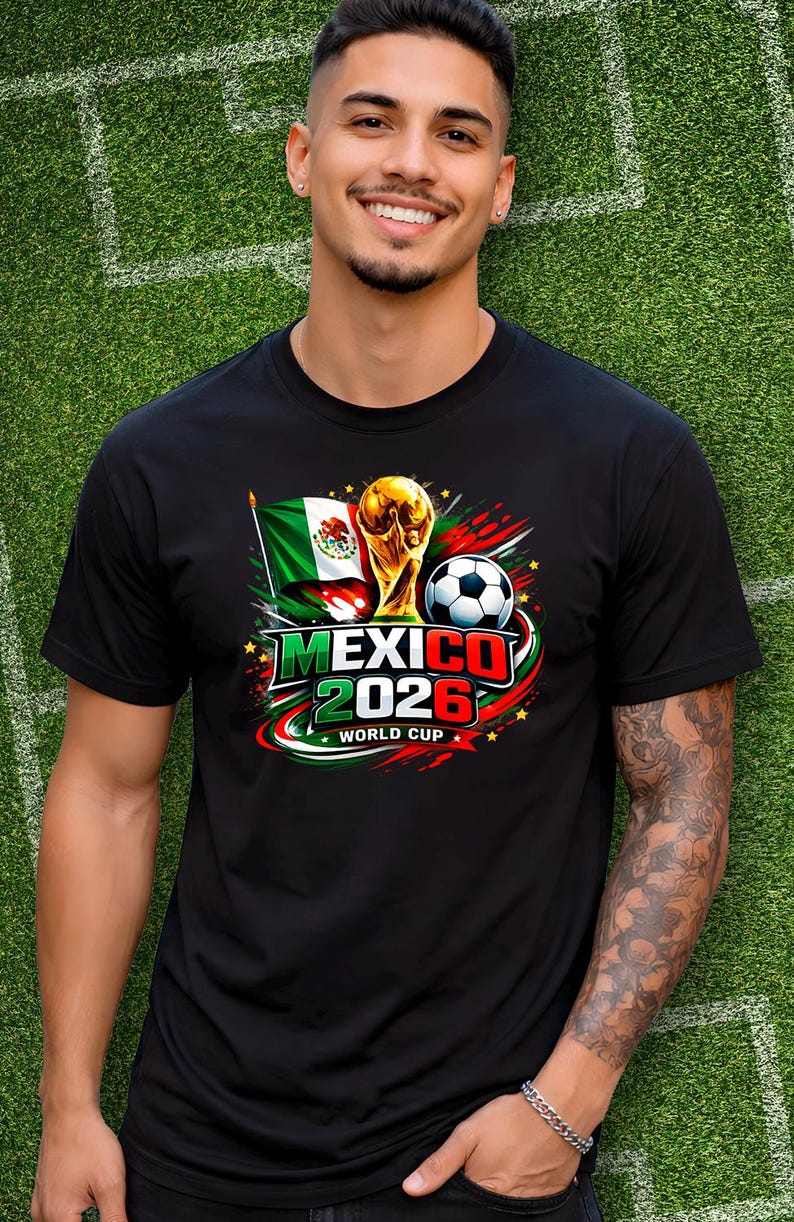 Puede incluir: Camiseta negra con un dise&ntilde;o gr&aacute;fico colorido que anuncia la Copa del Mundo de 2026 en M&eacute;xico. El dise&ntilde;o incluye la bandera mexicana, un bal&oacute;n de f&uacute;tbol y el trofeo de la Copa del Mundo. El texto "MEXICO 2026 WORLD CUP" es visible.