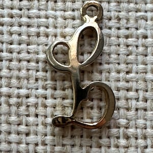 Pingente vintage dourado com letra cursiva "L"