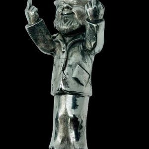 May include: A silver figurine of a man with a beard and mustache, wearing a jacket and pants. He is giving the middle finger with both hands.