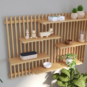 Peut inclure: Une étagère murale en bois avec plusieurs étagères et un design à lattes. Les étagères sont décorées de petits objets décoratifs, dont un lapin en céramique, un ours en céramique, un animal en céramique, un petit bol, une plante en pot et une bougie dans un bocal en verre.
