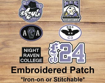 May include: A collection of embroidered patches with various designs, including a cowboy hat, dice, a raven, and the text "Night Raven College." The patches are in shades of purple, black, and white, with the words "Embroidered Patch" and "Iron-on or Stitchable" at the bottom.