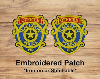 May include: Two embroidered patches with a blue and yellow police badge design. The badge reads "Officer Raccoon Police 1969" with a gold star in the center. The text "Embroidered Patch" and "Iron-on or Stitchable" are below the badges.