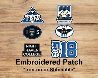 May include: A collection of embroidered patches in various shapes, featuring blue and white designs. The patches include text such as "IDIA", "Board Games Club", "NRC B28", "Night Raven College", and "218". The text "Embroidered Patch" is also present.
