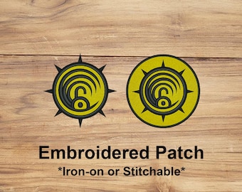 May include: Two embroidered patches with a yellow and black design. The patches feature a circular emblem with a stylized lock symbol. The text "Embroidered Patch" and "*Iron-on or Stitchable*" are displayed below the patches.