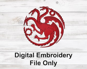 May include: Red dragon emblem with three heads, wings, and a circular design. The text "Digital Embroidery File Only" is below the emblem. The design is on a white wooden background.