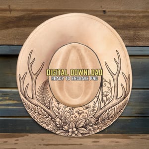 Könnte beinhalten: Ein beigefarbener Cowboyhut mit einem Geweih- und Blumendesign. Der Hut trägt den Text "DIGITAL DOWNLOAD READY TO ENGRAVE PNG". Der Rand ist mit detaillierten Illustrationen von Geweihen, Farnen und Blumen verziert.