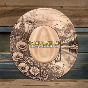 May include: A beige cowboy hat with a detailed engraved design. The design includes a mountain landscape, flowers, and the text "DIGITAL DOWNLOAD READY TO ENGRAVE PNG". The hat is set against a wooden background.