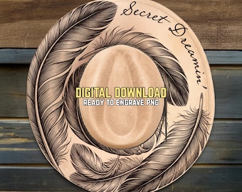 May include: A light brown cowboy hat design with a feather motif. The hat features the text "Secret Dreamin'" and "DIGITAL DOWNLOAD READY TO ENGRAVE PNG". The feathers are dark brown and surround the hat.