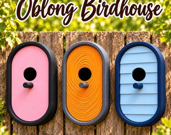 May include: Three oblong birdhouses with dark frames, each featuring a central circular entrance and a small perch. The left house is pink, the center house has an orange swirl texture, and the right house is light blue with horizontal slats.