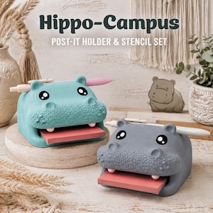 May include: Two hippo-shaped desk organizers in teal and gray, each featuring a wide mouth holding a stack of pink sticky notes and a slot on top for a pen. The text Hippo-Campus POST-IT HOLDER & STENCIL SET is displayed above the items.