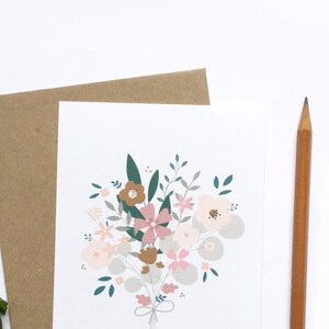 May include: A white card with a bouquet of pink, brown, and green flowers. The flowers are tied together with a brown ribbon.