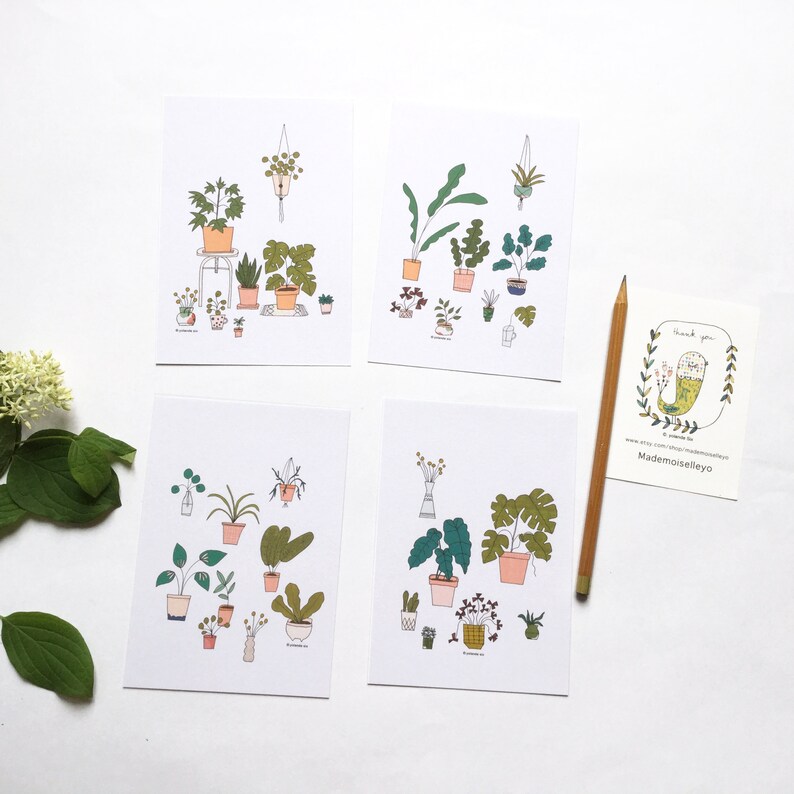 May include: Four printable cards featuring illustrations of potted plants. Each card has a different arrangement of plants, including ferns, succulents, and leafy plants. The cards are printed on white paper with black outlines and colorful accents.