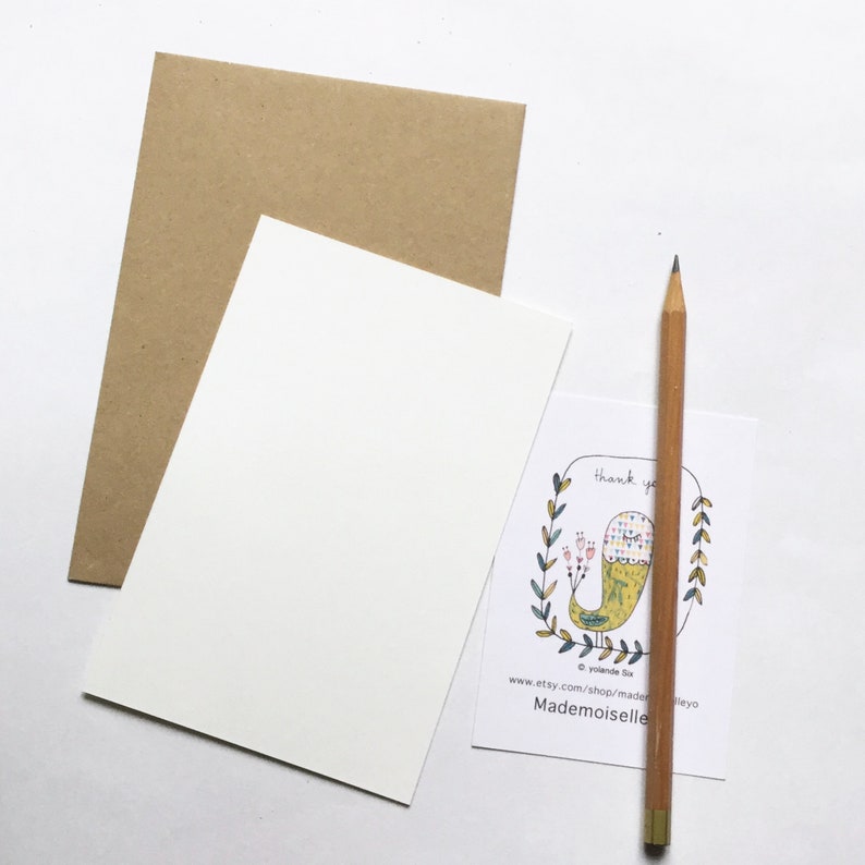 May include: A white card with a thank you message and a colorful illustration of a bird with a floral pattern. The card is surrounded by a green wreath. The text on the card reads "Thank you" and "Mademoiselle".