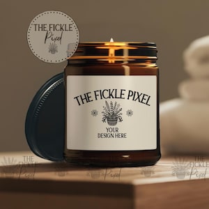 Op de afbeelding: Een bruine glazen kaars pot met een wit label. Het label heeft zwarte tekst die "THE FICKLE PIXEL" zegt en een zwart-witte illustratie van een plant in een pot. De tekst "YOUR DESIGN HERE" staat ook op het label.