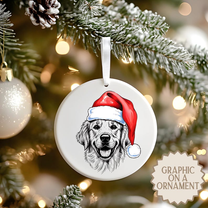 Op de afbeelding: Witte, ronde kerstversiering met een Golden Retriever met een kerstmuts. Het portret van de hond is in zwart-wit, met een rood-witte kerstmuts. De versiering hangt aan een wit lint. Tekst rechtsonder: "GRAPHIC ON A ORNAMENT."
