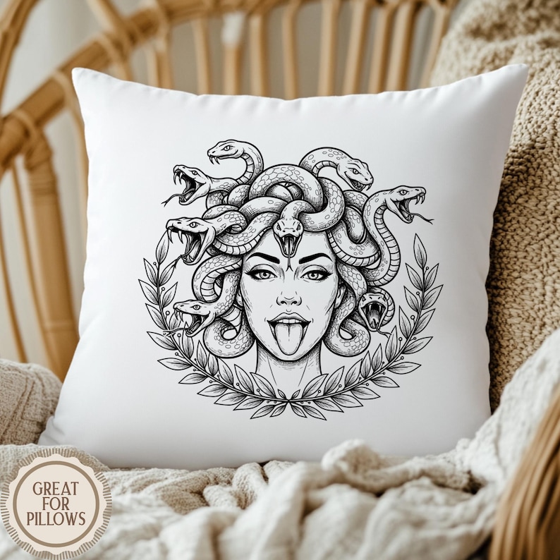 May include: White square pillow featuring a black and white illustration of Medusa with snakes for hair, a laurel wreath, and her tongue sticking out. The pillow has the text "GREAT FOR PILLOWS" in a circular design.