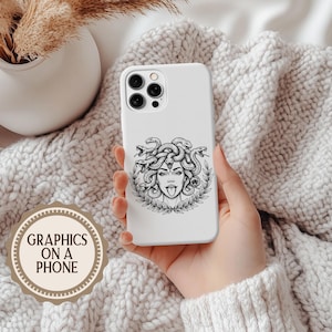 May include: White phone case featuring a black and white illustration of Medusa with snakes for hair, sticking out her tongue. The case is held in a hand against a soft, textured background. The text "GRAPHICS ON A PHONE" is in a circular logo.