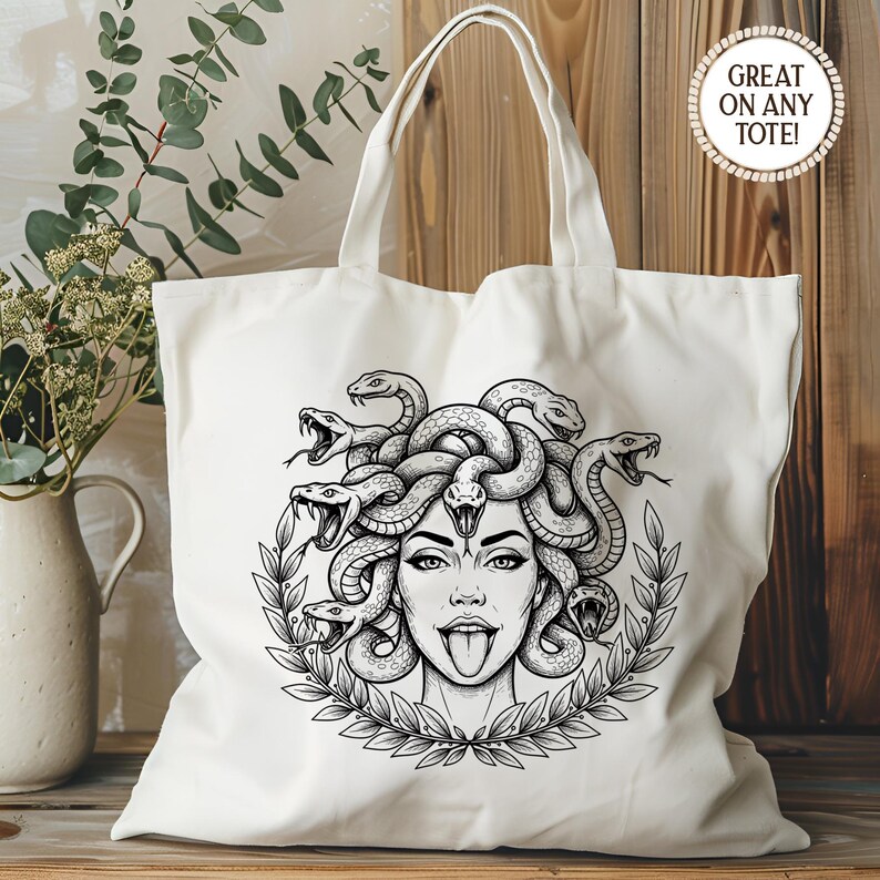 May include: Off-white tote bag featuring a black and white illustration of Medusa with snakes for hair, a tongue sticking out, and a laurel wreath. The text "GREAT ON ANY TOTE!" is in a circle on the upper right.