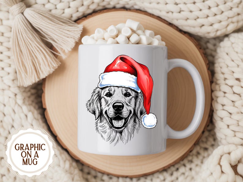 Op de afbeelding: Witte keramische mok met een illustratie van een Golden Retriever met een kerstmuts. De mok is gevuld met marshmallows en staat op een houten onderzetter. De tekst "GRAPHIC ON A MUG" staat linksonder.