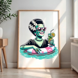Puede incluir: Impresión artística enmarcada que presenta una ilustración de dibujos animados de un personaje de piel verde en un flotador de piscina, con gafas de sol rosas y sosteniendo un cóctel. El personaje tiene el pelo negro y está sonriendo.