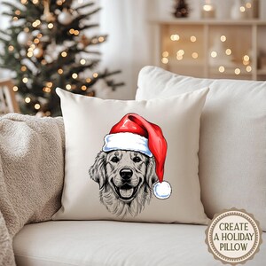 Op de afbeelding: Een beige vierkant kussen met een gedetailleerde illustratie van een Golden Retriever met een rode en witte kerstmuts. Het gezicht van de hond is gecentreerd, met een vrolijke uitdrukking. Het kussen ligt op een witte bank.