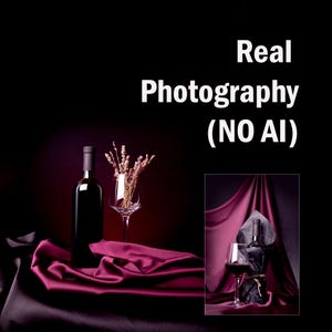 May include: A still life featuring a dark wine bottle, a wine glass with dried flowers, and a glass of red wine. The scene is set on a draped burgundy fabric, with the text "Real Photography (NO AI)" in the background.