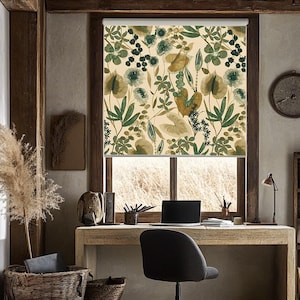 Può includere: Un ufficio domestico con una scrivania in legno, una sedia e tende. Le tende presentano un motivo botanico nei toni del verde e del beige. Sono visibili anche un laptop, una lampada e un orologio.