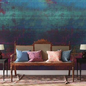May include: A living room scene featuring a wooden bench with patterned pillows, flanked by small black side tables with lamps. The backdrop is a textured wall with a blend of blue, teal, and purple hues, creating a vibrant and artistic ambiance.