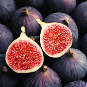 Peut inclure: Gros plan sur un groupe de figues mûres, certaines entières et d'autres coupées en deux, révélant leur chair rouge et leurs petites graines. Les figues sont disposées sur un fond sombre.