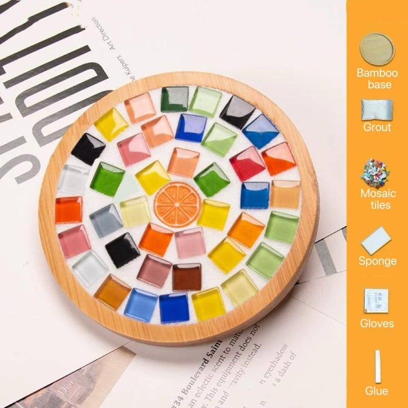 Pode incluir: Um porta-copos circular com base de bambu apresentando um design de mosaico com azulejos de vidro quadrados coloridos e um motivo central de fatia de laranja. O painel lateral exibe &iacute;cones e etiquetas para base de bambu, argamassa, azulejos, esponja, luvas e cola.