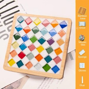 Pode incluir: Uma base quadrada de bambu contendo uma grade de azulejos de mosaico quadrados, coloridos e transl&uacute;cidos, fixados em argamassa branca. O lado direito apresenta um painel vertical laranja com etiquetas para base de bambu, argamassa, azulejos, esponja, luvas e cola.
