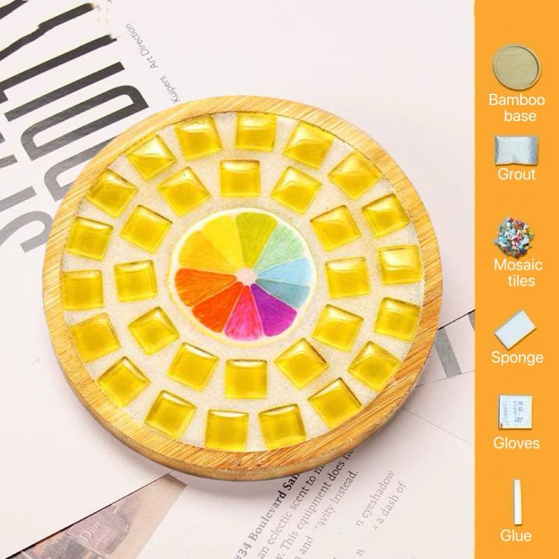 Pode incluir: Um kit de porta-copos circular de bambu com um design central de fatia de citrino rodeado por azulejos de mosaico quadrados amarelos. O kit inclui uma base de bambu, argamassa, azulejos, uma esponja, luvas e cola, rotulados &agrave; direita.