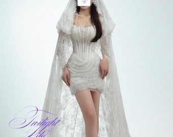 May include: A white lace dress with a long train and a fitted bodice. The dress has a sweetheart neckline and a short skirt. The model is wearing a white veil and has her hair pulled back. The text "Miola 1" is visible in the top right corner of the image.