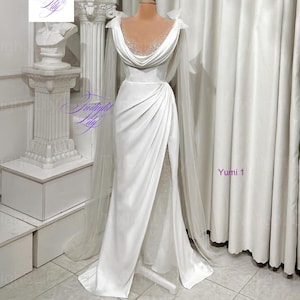 May include: A white satin gown with a draped bodice and a high slit. The dress features a cowl neckline embellished with sparkling details and sheer cape sleeves. The text "Twilight Lily" is visible in the image.