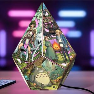 May include: A multi-faceted, diamond-shaped lamp featuring colorful anime-style illustrations. One panel shows a warrior with a white wolf, another depicts a couple with a small fire spirit, and the third displays a large, grey, furry creature.