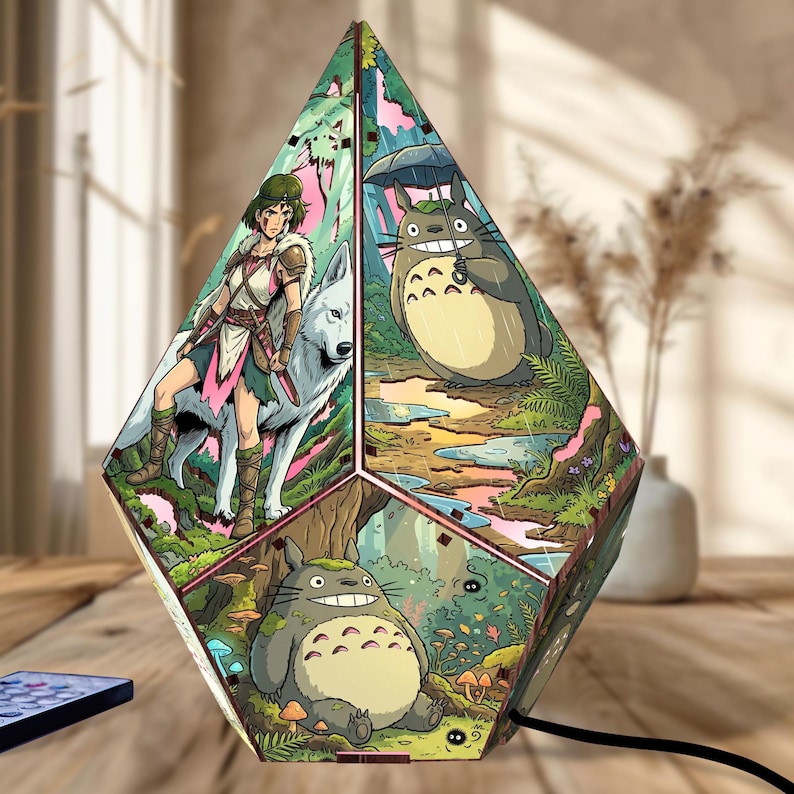 May include: A multi-faceted, diamond-shaped lamp featuring vibrant, colorful illustrations of anime characters. One panel depicts a warrior with a white wolf, another shows a large grey creature with an umbrella, and a third displays a forest scene.