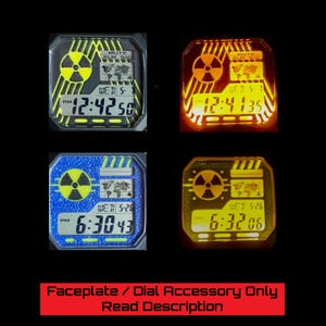 Puede incluir: Cuatro esferas de reloj digitales con un símbolo de radiación y un diseño de mapa del mundo. Las esferas muestran la hora y el día en diferentes colores: amarillo, naranja y azul. El texto "Faceplate / Dial Accessory Only Read Description" está en la parte inferior.